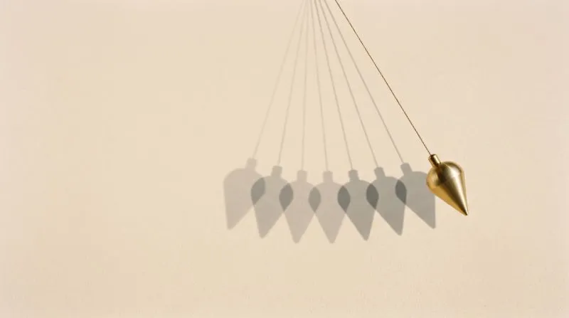 A brass pendulum caught mid-swing, its arc traced in soft shadow